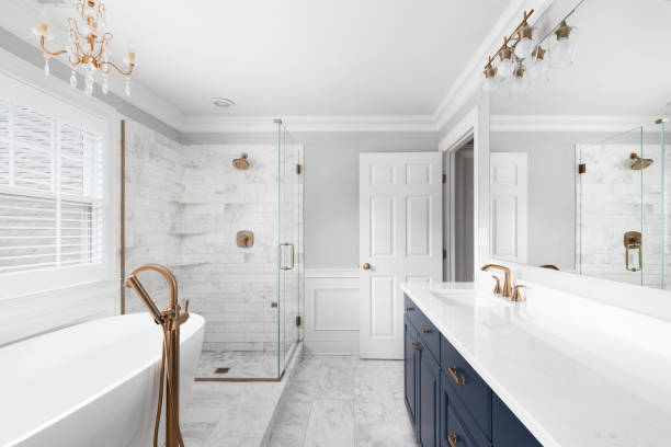 istockphoto-1450445015-612x612 A beautiful bathroom with a blue vanity cabinet, standalone bathtub and shower, and gold faucets.