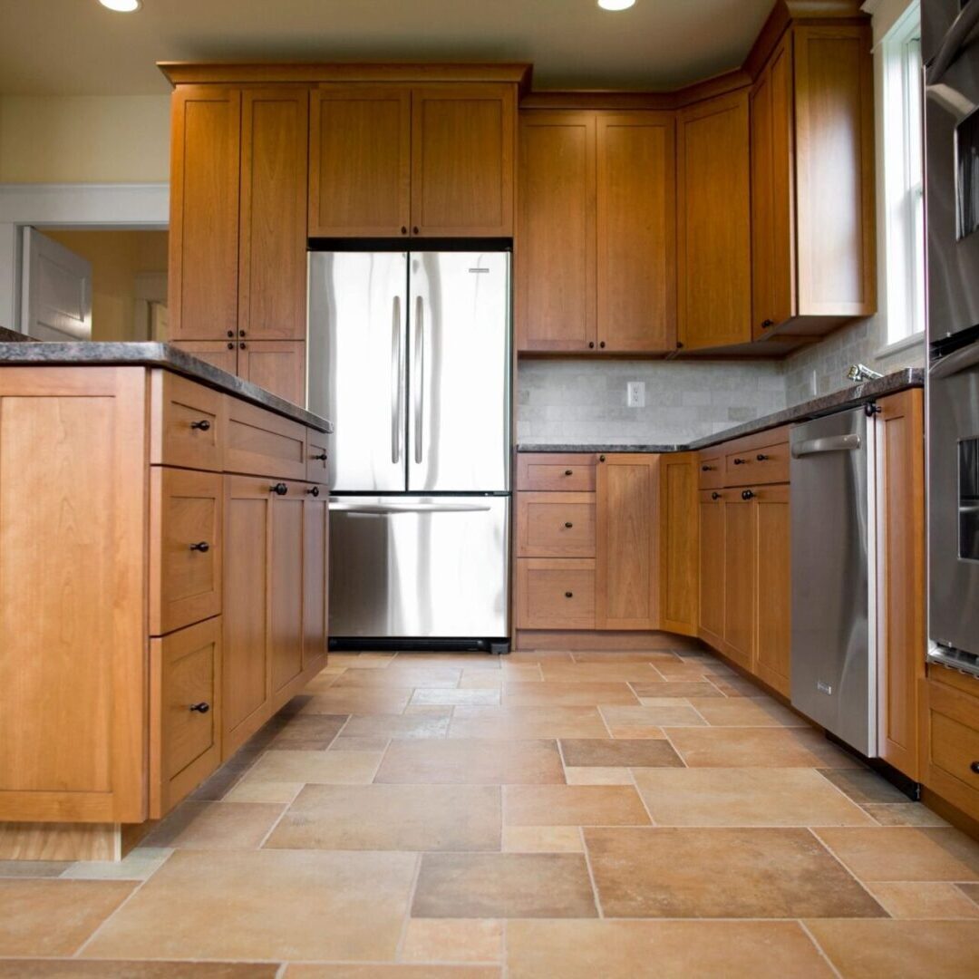 A kitchen with wooden cabinets and tile floors.